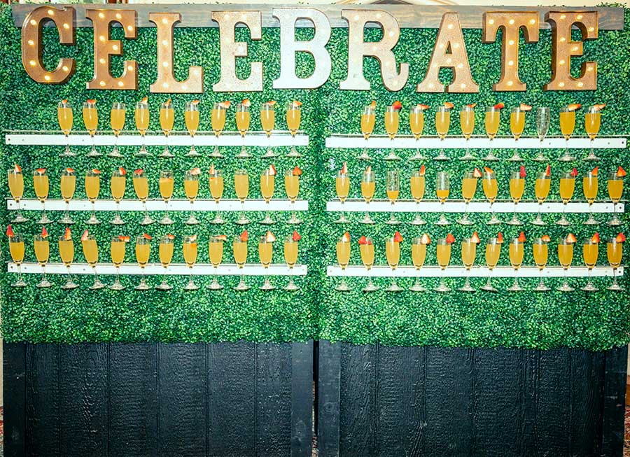 Hedge Wall with Celebrate Sign and Champagne Greeting