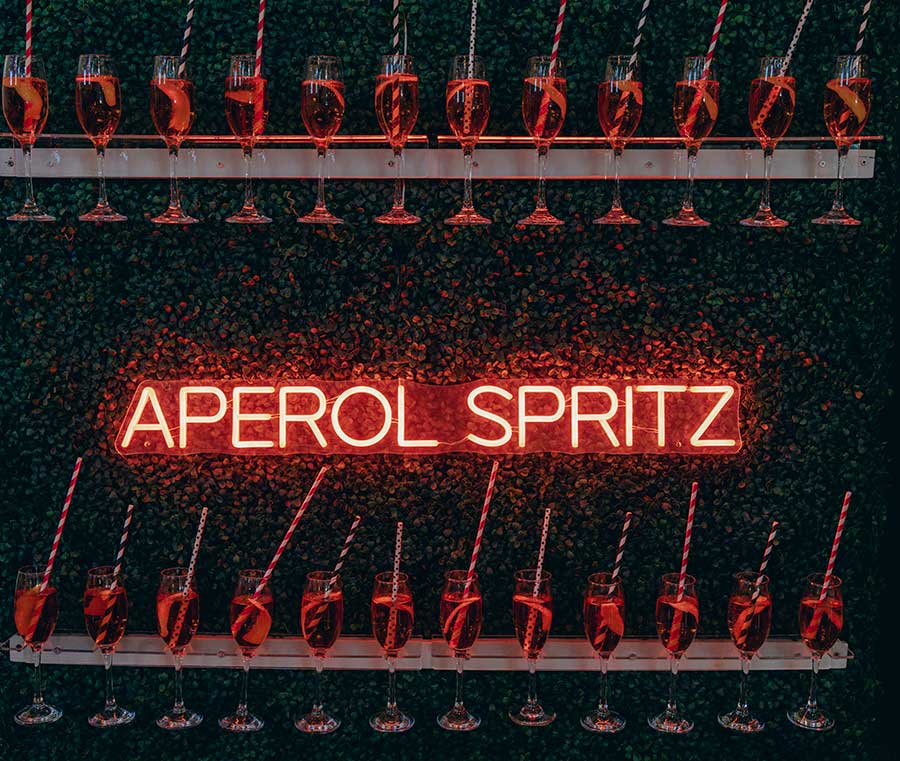 Hedge Wall with Aperol Spritz LED Sign